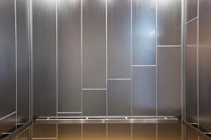 FSRT822 Интерьер лифта Levele-108 показан с верхними панелями из нержавеющей стали с зеркальной отделкой и эко-травлением с изображением городских огней; нижние панели из нержавеющей стали с отделкой кайзкой; прямоугольные перила на частном участке Forms-