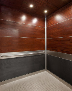 FSRT743 Интерьер лифта Levele-104 с верхними панелями из нестандартной деревянной фанеры; нижние панели из склеенной бронзы с темной патиной и треугольным узором; панели поручней из нержавеющей стали с отделкой из каймы; потолок из натурального шпона; кру