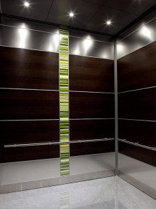 FSRT794 Интерьер лифта Levele-107 с основными панелями, облицованными шпоном дерева венге; акцентные панели из нержавеющей стали с льняной отделкой; панель лайтплана из стекла vivispectra elements с прослойкой юкки на частной территории Forms-surfaces