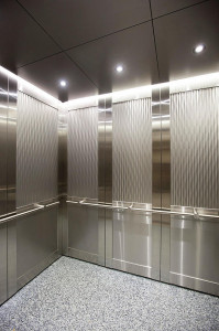 FSRT855 Внутреннее пространство лифта Levelc-2000n с верхними вставными панелями из нержавеющей стали, отделка морским камнем, углеродный узор; нижние вставные панели из нержавеющей стали, сатинированная, нестандартный рисунок эко-травления; стойки и пору Forms-surfaces 