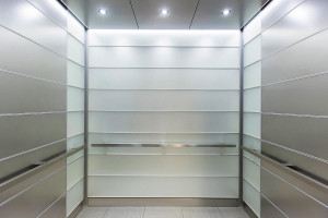 FSRT726 Интерьер лифта Levele-103 с индивидуальной компоновкой панелей; панели из вивихромового хромового стекла с прослойкой индивидуального цвета и отделкой opalex, а также из нержавеющей стали с отделкой из песчаника; квадрантные поручни в корпоративно