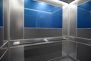 FSRT717 Интерьер лифта Levele-102 с индивидуальной компоновкой панелей; основные панели из клееного алюминия с естественной патиной и рисунком травы; центральные акцентные панели из стекла vivichrome chromis с прослойкой индивидуального цвета и стандартно Forms-surfaces 