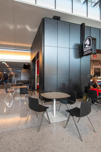 FSRT638 Система обшивки стен Levelr с панелями из вивихромного хромисового стекла в отражающей конфигурации с прослойкой индивидуального цвета и отделкой opalex, а также изготовленными на заказ выступающими ребрами черного цвета в международном аэропорту